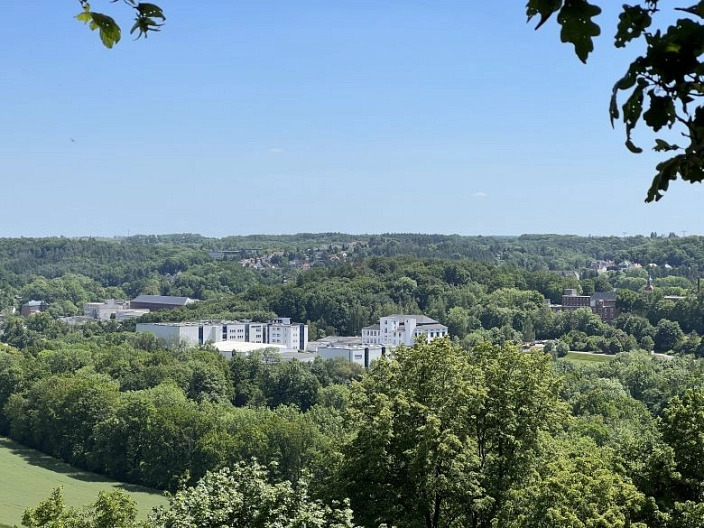 Blick im Stufenberg im Wald auf das Gebäude von Florena, welches von Wald umgeben ist.
