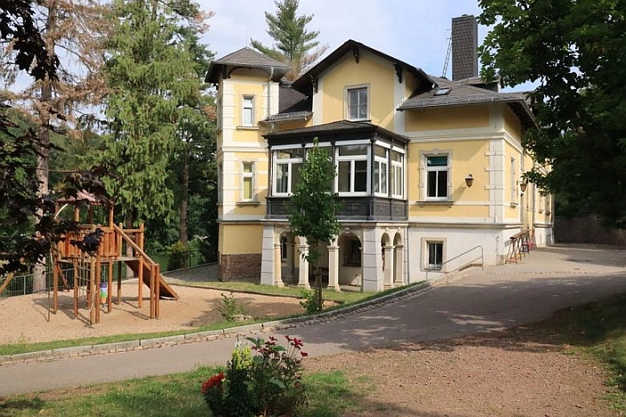 Kindertagesstätte Zschopauknirpse
Gelbe Villa mit Klettergerüst davor. Zur Villa führt ein Weg