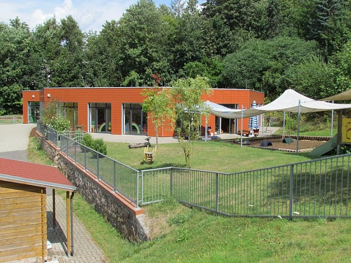 Kita Zschopauknirpse Krippe
Eingezäunte Spielwiese mit Kindergartengebäude