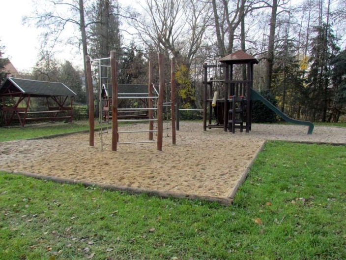 Gesamtansicht Spielplatz Meinsberg mit Sitzgelegenheit im Hintergrund