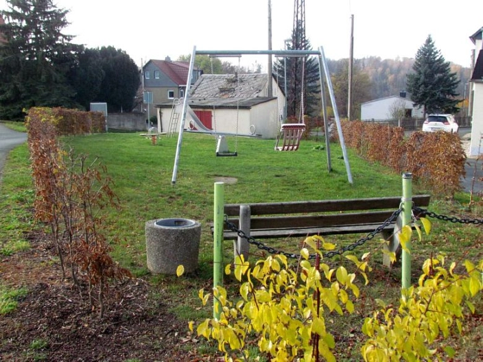 Blick aus Richtung der Sitzbank auf die Schaukel des Spielplatzes in Schönberg